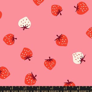 May include: A pink fabric with a repeating pattern of red and white strawberries. The strawberries have green stems and are scattered across the surface. The fabric has the text "RUBY STAR SOCIETY" at the bottom.