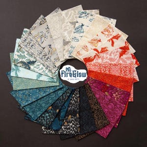 May include: A collection of fabric squares arranged in a circle, showcasing diverse patterns and colours. The fabrics feature dragon and floral motifs in blue, red, pink, and gold. The centre displays the text "FireGlow by Sarah Watts" within a circular logo.