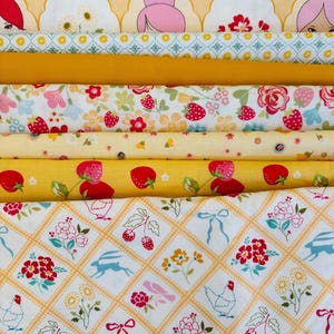 Peut inclure: Une pile de tissus à motifs variés dans les tons de jaune, blanc et rose. Les motifs comprennent des fraises, des fleurs et des motifs géométriques. Certains tissus présentent des illustrations de lapins, de poulets et de nœuds. Idéal pour le patchwork ou les projets de couture.