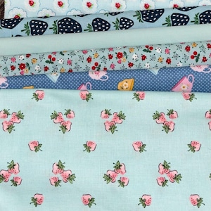 Peut inclure: Une pile de tissus en coton avec différents motifs floraux et fruités. Les motifs comprennent des fraises, des fleurs et des tasses à thé dans des tons de bleu, rose et blanc. Parfait pour les projets de patchwork et d'artisanat.