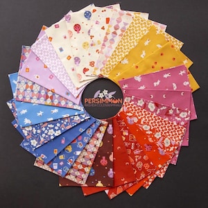 Peut inclure: Un éventail circulaire d'échantillons de tissu dans un spectre de couleurs incluant jaune, rose, rouge, marron, bleu et violet. Chaque échantillon présente des motifs uniques comme des fleurs, des formes géométriques et des icônes. Une étiquette centrale indique PERSIMMON RASHIDA COLEMAN HALE.