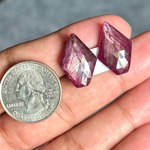Puede incluir: Dos piedras preciosas de rubí rosa con forma de diamante facetado. Las piedras preciosas son aproximadamente del tamaño de una moneda de 1 euro.