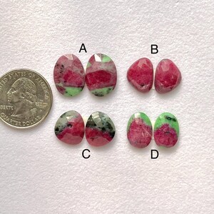 Puede incluir: Cuatro pares de gemas facetadas de diversas formas y colores. Las gemas presentan tonos rojos, verdes y grises. Se incluye una moneda de cuarto de dólar estadounidense para comparar el tamaño, de aproximadamente 2,4 cm de diámetro.