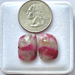 Könnte beinhalten: Zwei facettierte, kissenförmige Edelsteine mit rosa und weißer Färbung werden neben einem US-Vierteldollar gezeigt. Die Edelsteine haben eine Mischung aus rosa und weißen Farbtönen mit einigen Einschlüssen. Der Vierteldollar ist silberfarben und zeigt das Profil von George Washington.