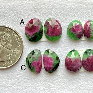 Puede incluir: Una variedad de gemas facetadas con una moneda de cuarto de dólar estadounidense para comparar el tamaño. Las gemas, de forma ovalada, muestran una mezcla de tonos verdes, rosas y rojos. Las gemas están etiquetadas A, B, C y D.