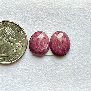 May include: A white ceramic mug with a black handle and the text "But First, Coffee" in a bold, black font. The mug is set against a blurred background, suggesting a cozy setting.