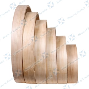 May include: A set of six wooden hoops of varying sizes, stacked in a graduated pattern. The hoops are made of light-colored wood and have a smooth, polished finish.