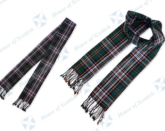 May include: A green, orange, and blue plaid scarf with black fringe. The scarf is folded in half and laid flat on a white background.