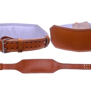 May include: A brown leather weightlifting belt with a white stitched border and a silver buckle. The belt has multiple rows of small holes for adjusting the fit.