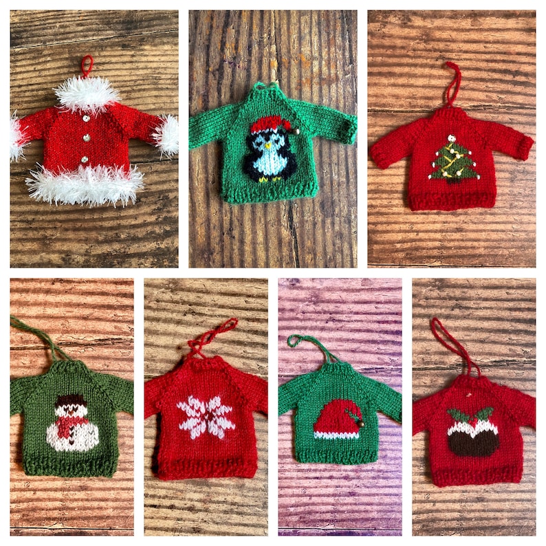 May include: Eight knitted Christmas decorations shaped like jumpers with various designs. The decorations are red, green and white. The designs include a snowman, a snowflake, a penguin, a Christmas tree, a Christmas pudding and a Santa hat.