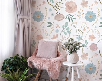 May include: A white chair with a pink faux fur seat cushion and a pink pillow sits in front of a wall with a floral wallpaper pattern. The wallpaper features pink, blue, and green flowers on a white background.