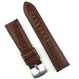 May include: Two-piece brown leather watch strap with a crocodile pattern. The strap has a stainless steel buckle and is designed to attach to a watch face. The leather is a rich, dark brown color.