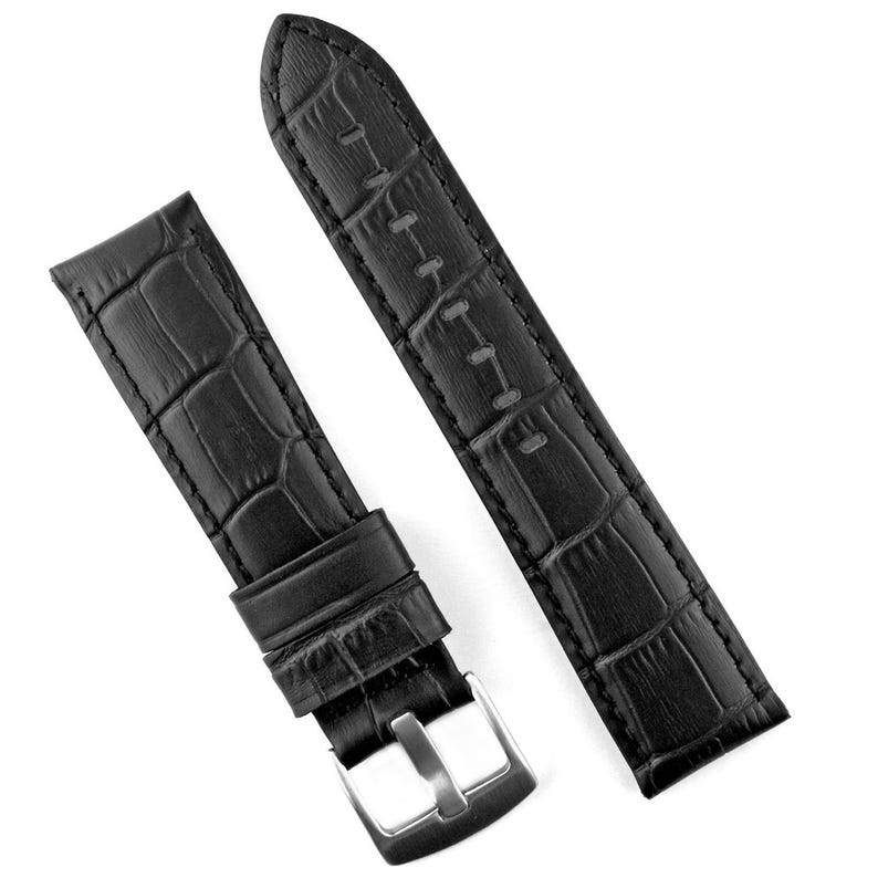 May include: Black watch strap with a crocodile pattern. The strap features a silver-colored buckle and a textured surface. The watch band is made of a durable material and is designed to be a replacement for a watch.