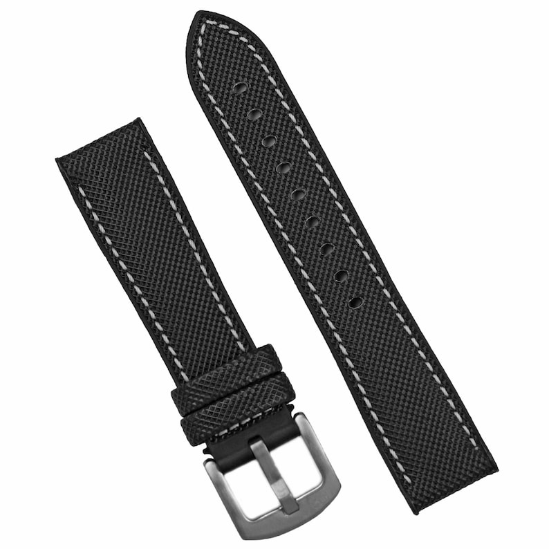 Puede incluir: Correa de reloj negra con costuras blancas y hebilla plateada.