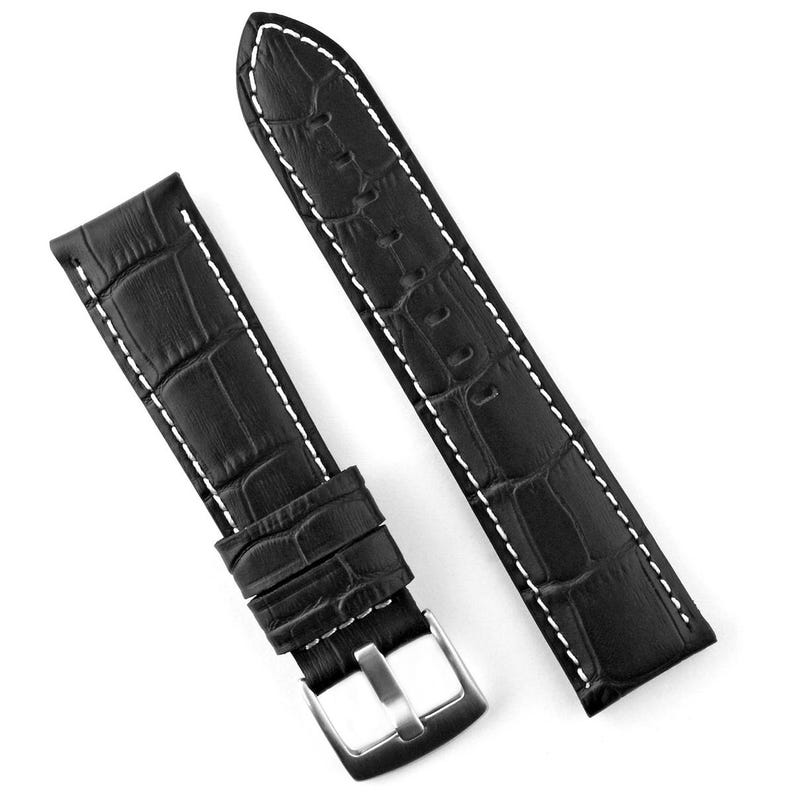 May include: Black watch band with a crocodile pattern and white stitching. The band has a silver-colored buckle. The watch band is made of leather.