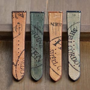 May include: Four leather watch straps in shades of brown, green, and blue-grey. Each strap features printed text and a series of holes for adjustment. The straps are labeled "Shell Cordovan" and "Genuine".