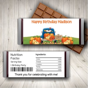 May include: A chocolate bar wrapper with a fall theme. The wrapper features a blue truck with pumpkins in the back, a sign that says "Pumpkin Patch", and the text "Happy Birthday Madison". The back of the wrapper has a nutrition facts label and a list of ingredients, including smiles, friends, laughter, family, and memories.