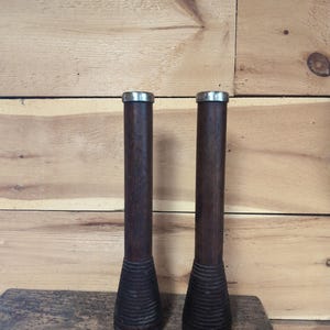 Vintage pair of woolen frame bobbins with steel bindings on top, 12 inches tall