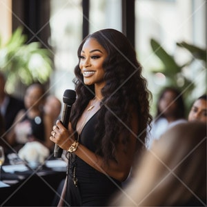 May include: A woman with long black hair speaks into a microphone while wearing a black sleeveless dress and a gold necklace. She is smiling and looking to the side.