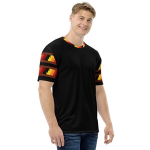 May include: Black short-sleeved t-shirt with a yellow, orange, and red geometric pattern on the sleeves.