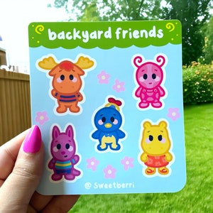 May include: A set of six colourful stickers featuring cartoon animals with the text "backyard friends" and the artist's signature "@Sweetberri". The stickers feature a moose, a ladybug, a blue bird, a kangaroo, and a yellow bear.