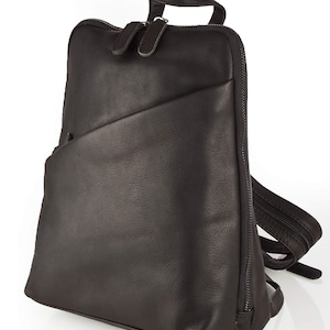 May include: A brown leather backpack with a zipped front pocket and adjustable straps.