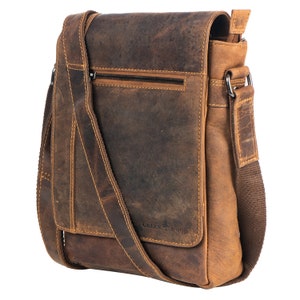May include: A brown leather messenger bag with an adjustable shoulder strap. The bag has a zippered pocket on the front and the text "GREEN WOOD" is printed on the front.