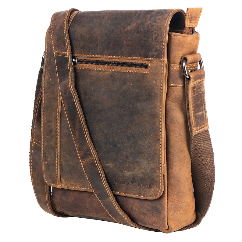 May include: A brown leather messenger bag with an adjustable shoulder strap. The bag has a zippered pocket on the front and the text "GREEN WOOD" is printed on the front.