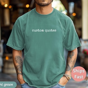 K&ouml;nnte beinhalten: Hellgr&uuml;nes T-Shirt mit dem wei&szlig;en Text "custom quotes". Das Shirt ist einfarbig und hat eine lockere Passform. Die &Auml;rmel sind kurz und der Ausschnitt ist rund. Das Shirt ist aus einem weichen Material.