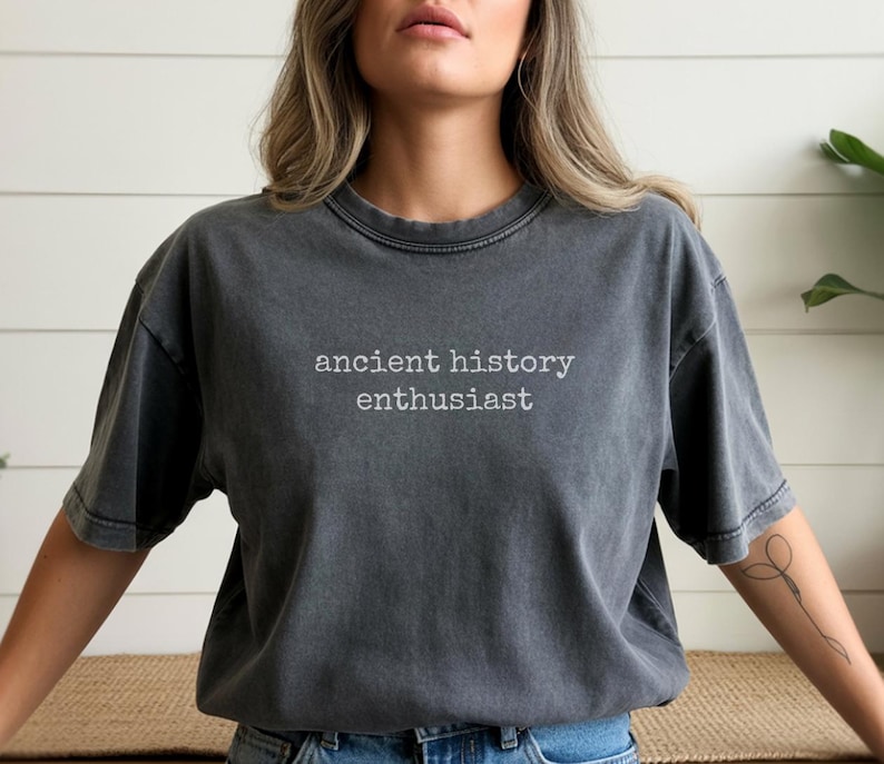 Pu&ograve; includere: T-shirt grigio scuro con la scritta bianca "ancient history enthusiast". La maglietta ha maniche corte e girocollo. La maglietta &egrave; realizzata in un materiale morbido e confortevole.