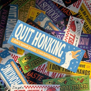 May include: A collection of colorful stickers with various phrases and designs. One sticker features a cartoon goose with the text "Quit Honking! I don't speak goose. I can barely read it."