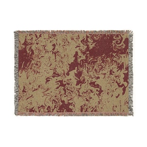 May include: A rectangular throw blanket with a swirling pattern in shades of burgundy and tan. The edges are finished with a fringe in a neutral color. The blanket's design has a marbled effect.