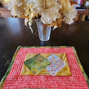 Pode incluir: Um corredor de mesa acolchoado com um padrão de diamante em tons de verde, amarelo e vermelho. O corredor de mesa tem um fundo vermelho com uma borda verde e amarela.