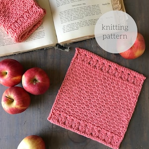 May include: A pink knitted dishcloth with a scalloped border. The dishcloth is lying on a wooden surface with apples around it. The text "knitting pattern" is written in white on a circle.
