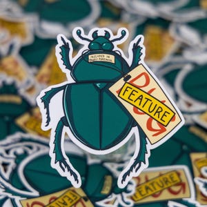Puede incluir: Una pegatina con un escarabajo verde azulado con una etiqueta que dice "FEATURE" en letras rojas. El escarabajo tiene un contorno blanco y está sobre un fondo de pegatinas similares. La pegatina también tiene el texto "INCLUDED IN EVERY PURCHASE".