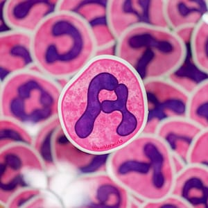 May include: A collection of pink and purple stickers featuring a stylized cell design. The central sticker, in focus, has a pink background with a purple, amoeba-like shape. The text "@warblerworks" is visible on the sticker.