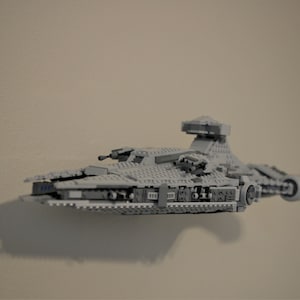 May include: A grey Lego Star Wars TIE Interceptor starship model.