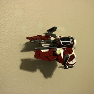 以下が含まれることがあります： 黒のコックピットと緑のディテールを持つ赤と白のレゴスターウォーズ戦闘機