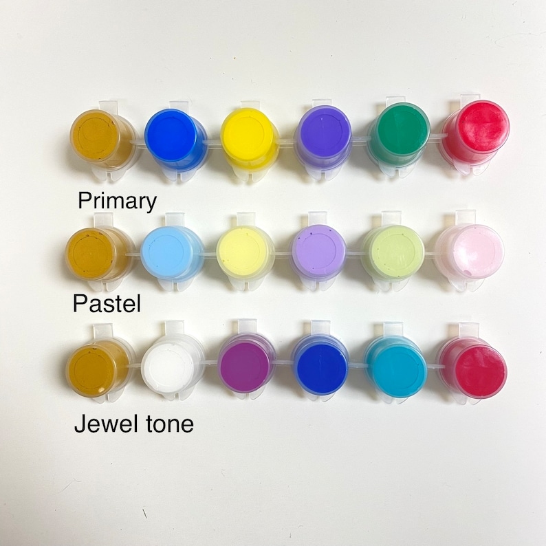 May include: Three rows of paint pots, each row labeled with a color category: Primary, Pastel, and Jewel tone. The first row contains yellow, blue, red, green, and brown paint pots. The second row contains light yellow, light blue, lavender, light green, and pink paint pots. The third row contains dark blue, purple, teal, red, and white paint pots.
