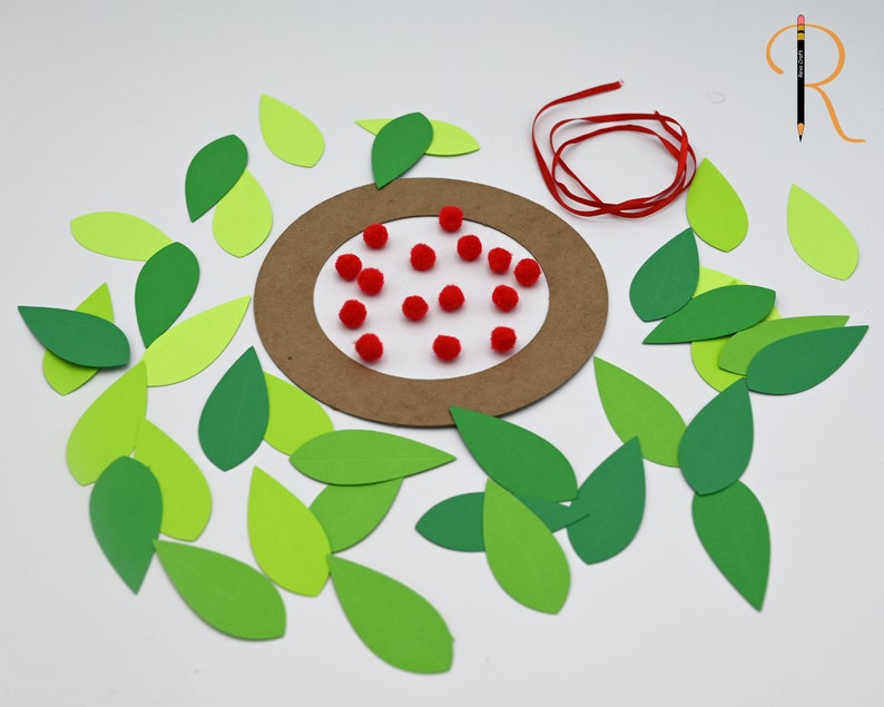 May include: A craft project with a brown paper circle, red pom-poms, and green paper leaves.