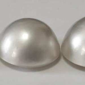 Peut inclure: Trois cabochons de perles blanches de tailles différentes. Les perles sont lisses et ont un fort lustre.