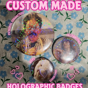 Op de afbeelding: Holografische badges met afbeeldingen van fictieve personages, beroemdheden, huisdieren en geliefden. De badges zijn rond en hebben een glanzende, iriserende afwerking. De tekst "CUSTOM MADE" en "HOLOGRAPHIC BADGES" is roze.