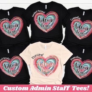 May include: Black and tan t-shirts with a heart-shaped design that says "Admin Team." Each shirt has a different title above the heart, including "Testing Coordinator," "Assistant Principal," and "Counselor." The bottom of the image says "Custom Admin Staff Tees!"