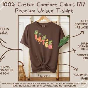 May include: Espresso-colored unisex t-shirt with the word "LATER" in colorful letters and cartoon alligators. The shirt is made of pre-shrunk, ring-spun US cotton and is garment-dyed. Printed in the U.S.A. with direct to garment printing.