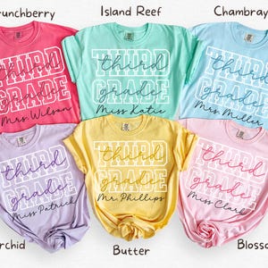 May include: Six short-sleeved crewneck t-shirts in pink, teal, light blue, lavender, yellow, and light pink. Each shirt features the white block text THIRD GRADE with a cursive name underneath: Mrs. Wilson, Miss Katie, Mrs. Miller, Miss Patrick, Mr. Phillips, and Miss Clark.