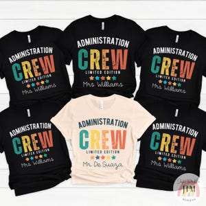 May include: A collection of black and cream-colored t-shirts with the words "ADMINISTRATION CREW" in a colorful, retro design. Each shirt includes the text "LIMITED EDITION" and a name below the design.