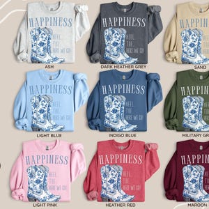 May include: Crewneck sweatshirts in a range of colours, each with a graphic of a blue and white floral cowboy boot and the text "HAPPINESS". Colours include ash, dark heather grey, sand, light blue, indigo blue, military green, light pink, heather red, and maroon.