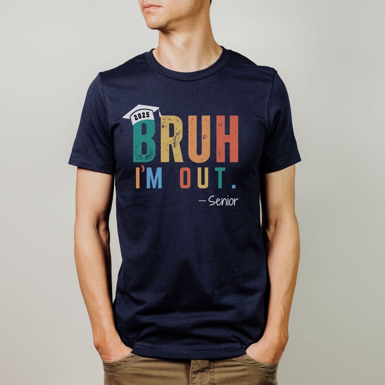 May include: A navy blue t-shirt with a colorful graphic that says "BRUH I'M OUT. -Senior" with a graduation cap and the year 2025.