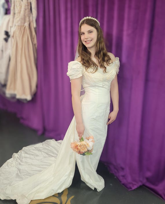 Sweet vintage 100 percent silk bridal gown with detachable train, darling rosettes & a pearl neckline. Sample size 8. Never been worn.