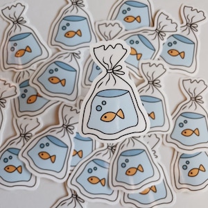 May include: A collection of white vinyl stickers featuring a cartoon illustration of a goldfish in a plastic bag. The stickers are arranged in a random pattern on a white background.